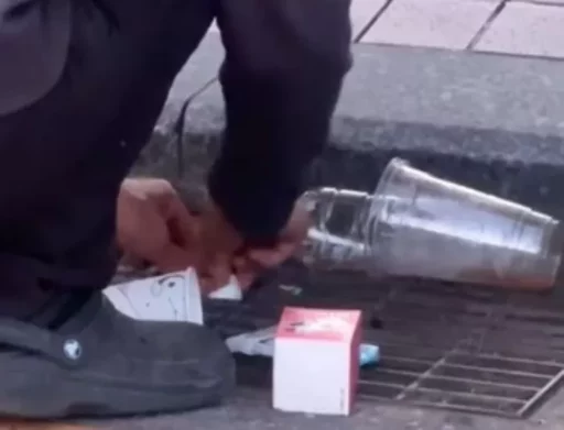 “Trying to save on trash bags?”… A man ‘carefully’ stuffing garbage into a drain.