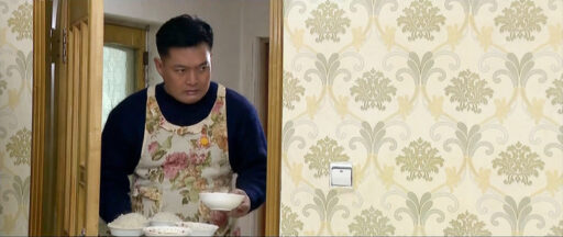 “Is a man in North Korea wearing a floral apron serving food in a drama?”
